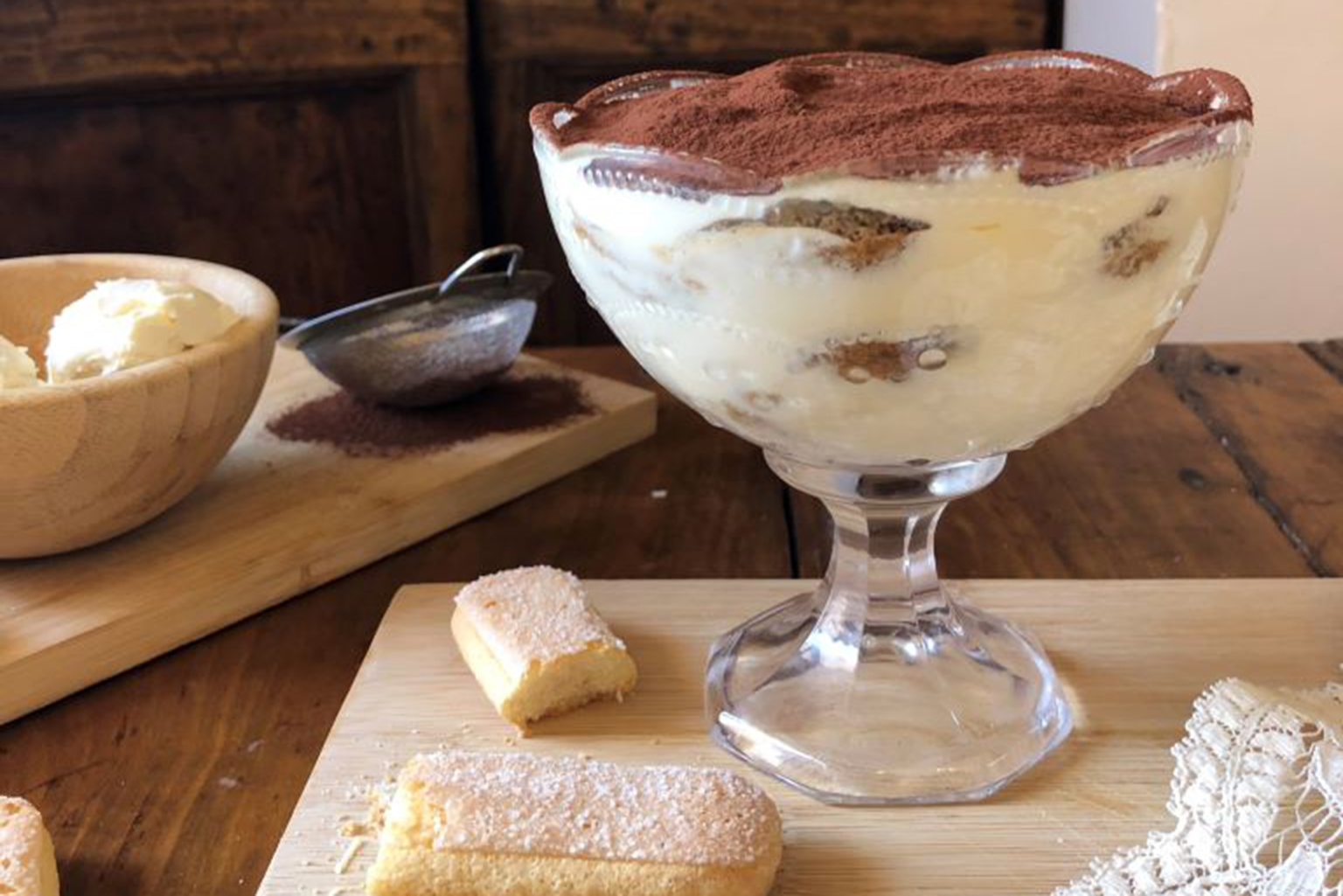 a bowl of dessert sitting on top of a wooden table.